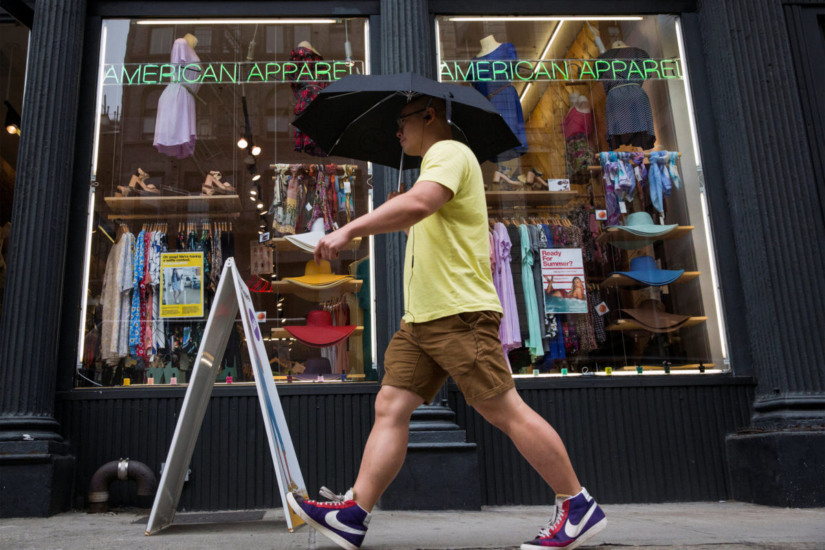 FILE PHOTO: A man walks past an American Apparel store in New York June 19, 2014. REUTERS/Brendan McDermid/File Photo
